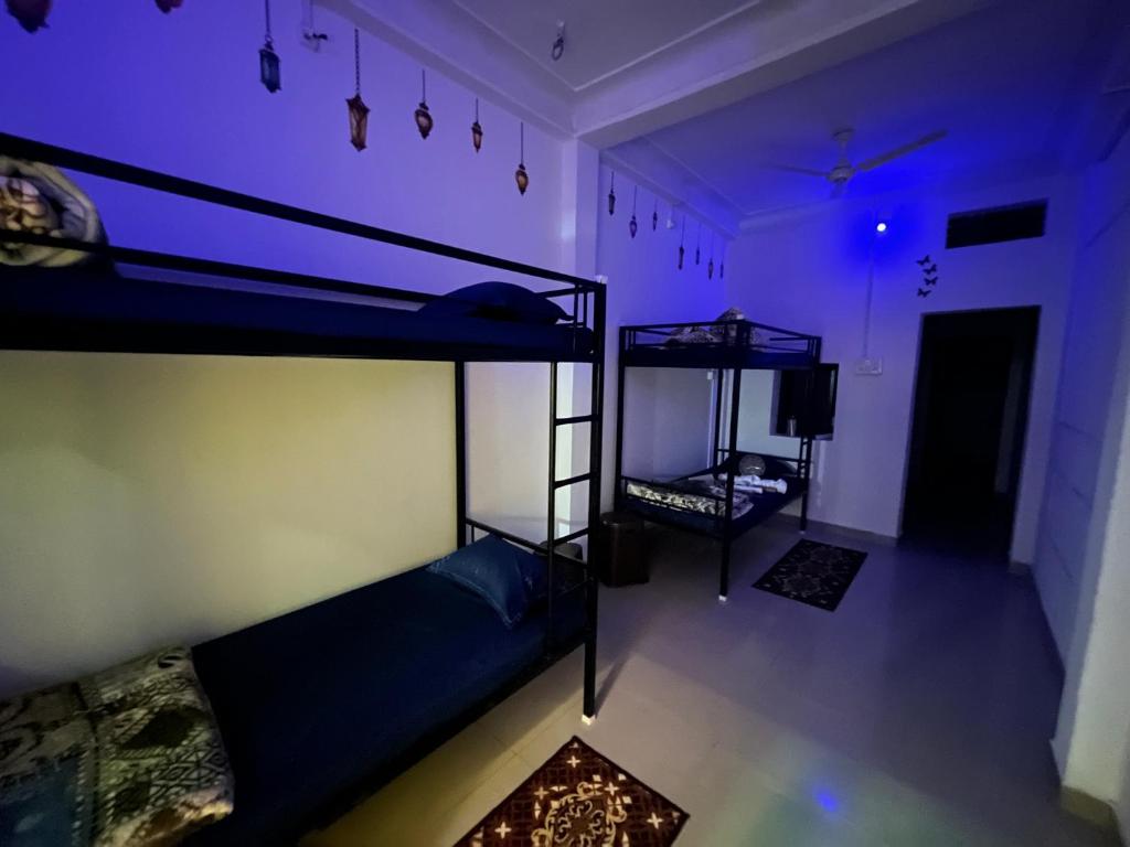 乌贾因Spiritual Backpackers Hostel的紫色灯房内的两张双层床