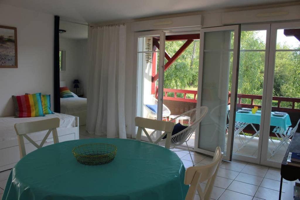 阿雷斯appartement cosy et nature au coeur du Bassin的客厅设有绿桌和阳台。