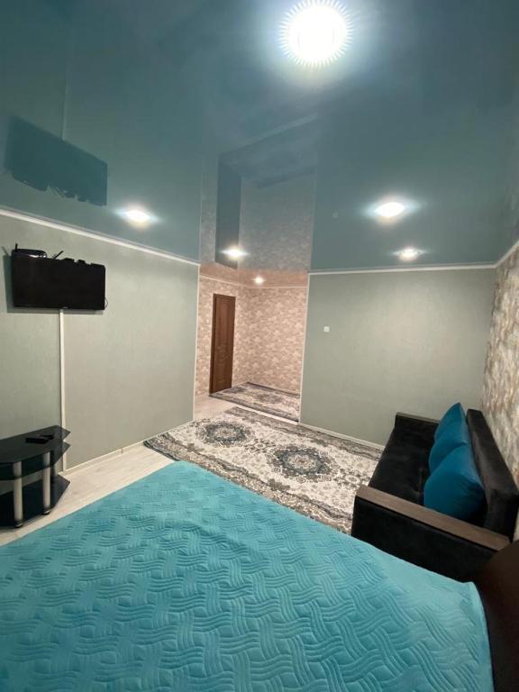 乌斯季卡缅诺戈尔斯克Однокомнатные апартаменты的客房设有床、电视和沙发。