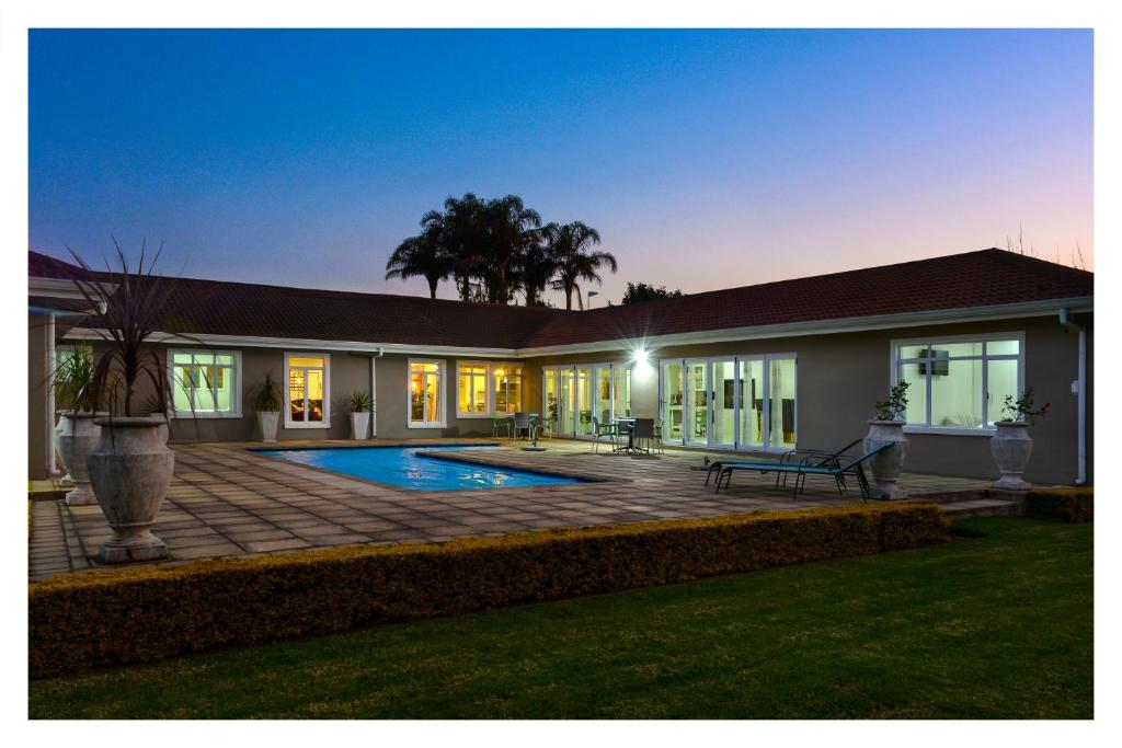 希尔顿66 On Monzali 4 Star Luxury Guesthouse的一座房子前面设有游泳池