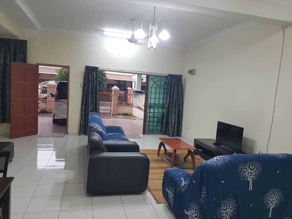 汝来Damai Eco Homestay Nilai Negeri Sembilan的客厅配有2张蓝色沙发和电视