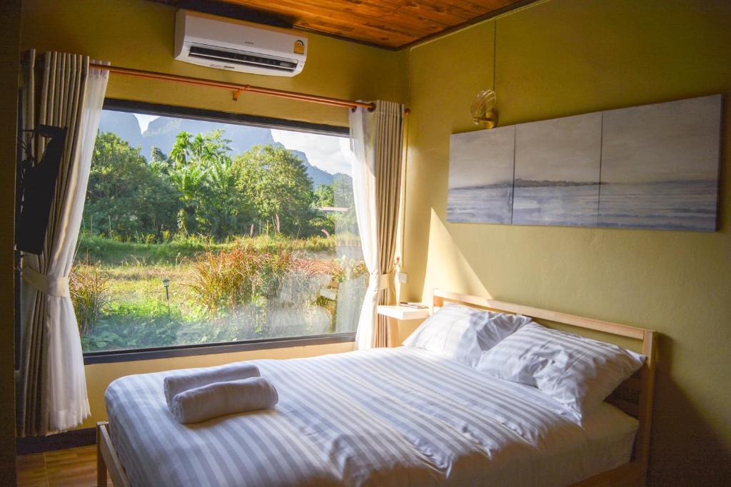 攀牙Phangnga Save House - เซฟเฮาส์พังงา的一间卧室设有一张床和一个美景窗户。