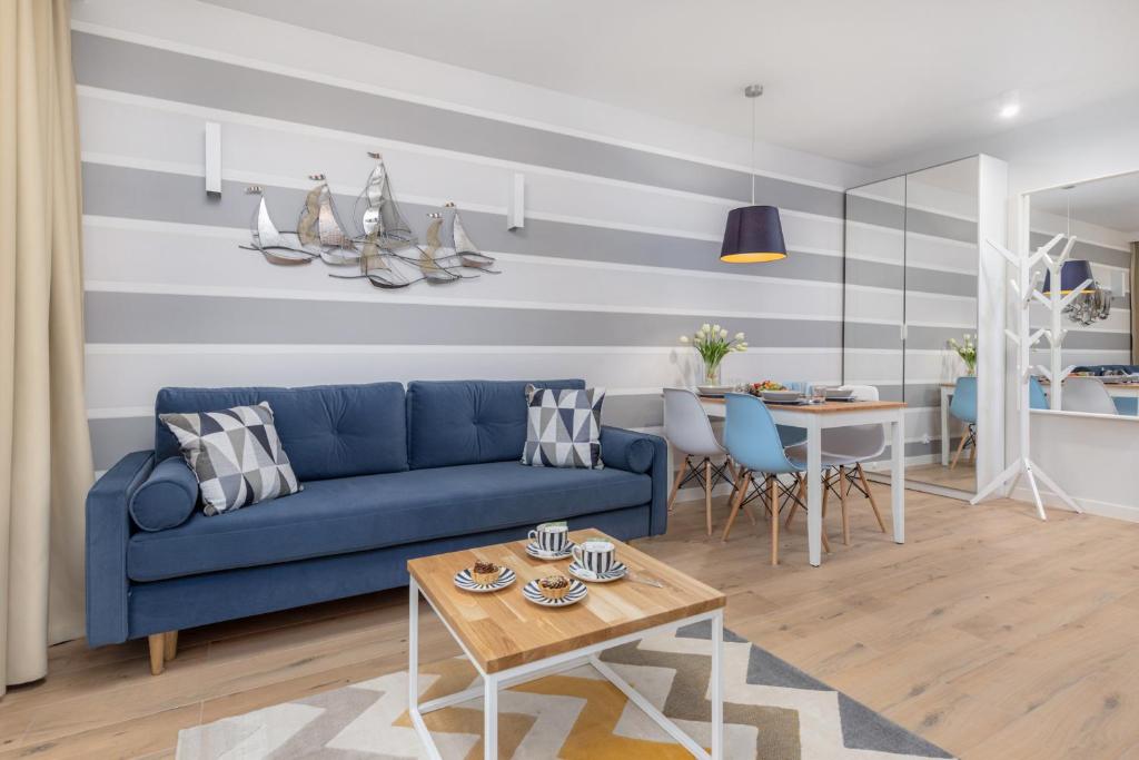 波别罗沃Pobierowo Beach Baltic Apartments by Renters的客厅配有蓝色的沙发和桌子