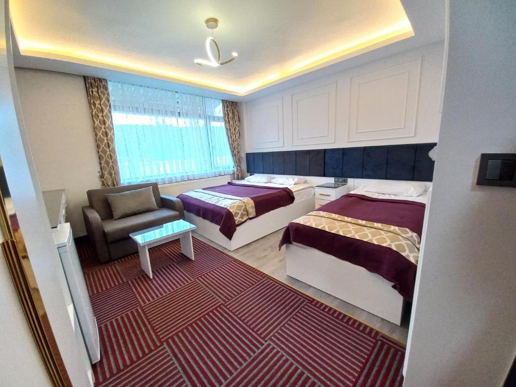 AltındağGRAND BELLİ OTEL的酒店客房,配有两张床和椅子