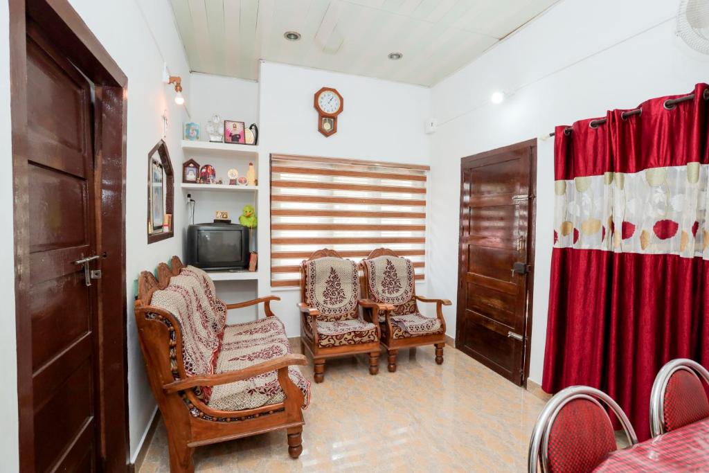 安娜维拉缇Koonamparayil Home Stay Munnar Anaviratty-Family Only的客厅配有椅子和电视