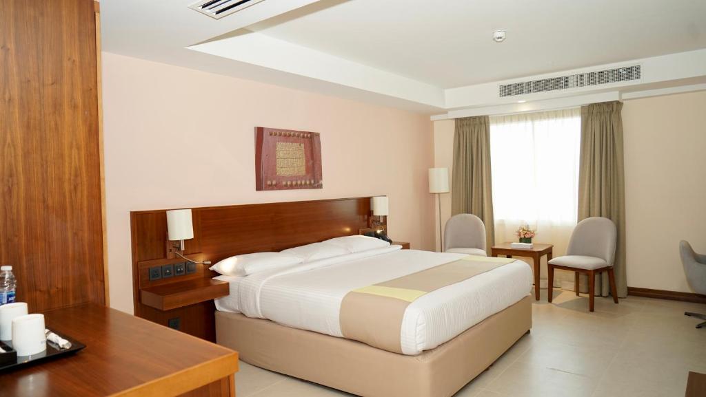 塞拉莱KYRIAD HOTEL SALALAH的配有一张床和一张书桌的酒店客房