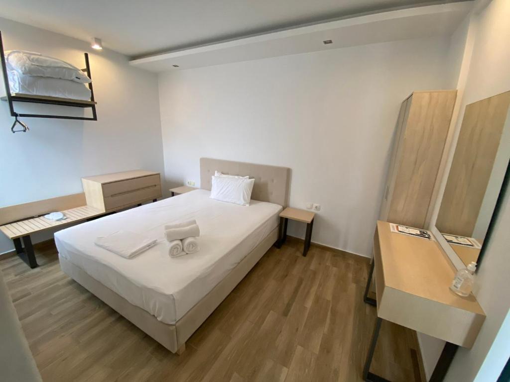奥弗里安Coral Boutique Apartments的卧室配有白色的床,铺有木地板