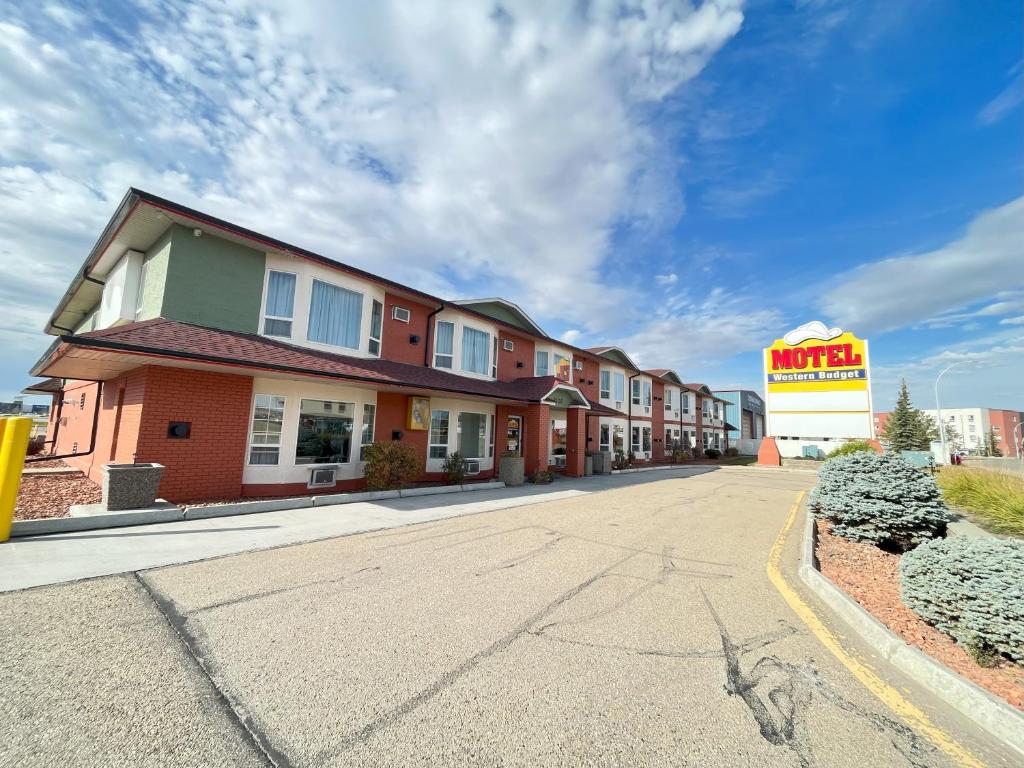 勒杜克Western Budget Motel #1 Leduc/Nisku的路边有汽车旅馆标志的建筑