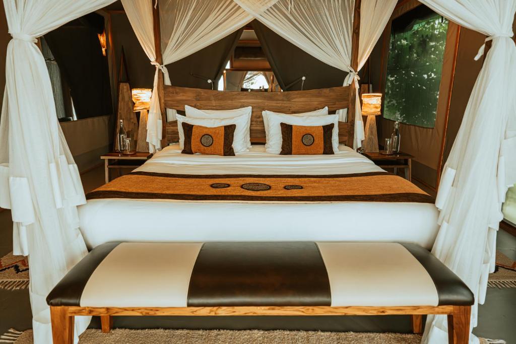 SekenaniSoroi Luxury Migration Camp的一间卧室配有一张带天蓬的大床