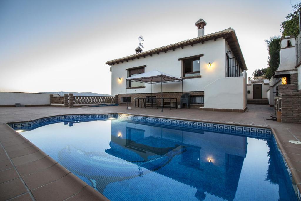 杜尔卡尔Casa Vistas del Valle的别墅前设有游泳池