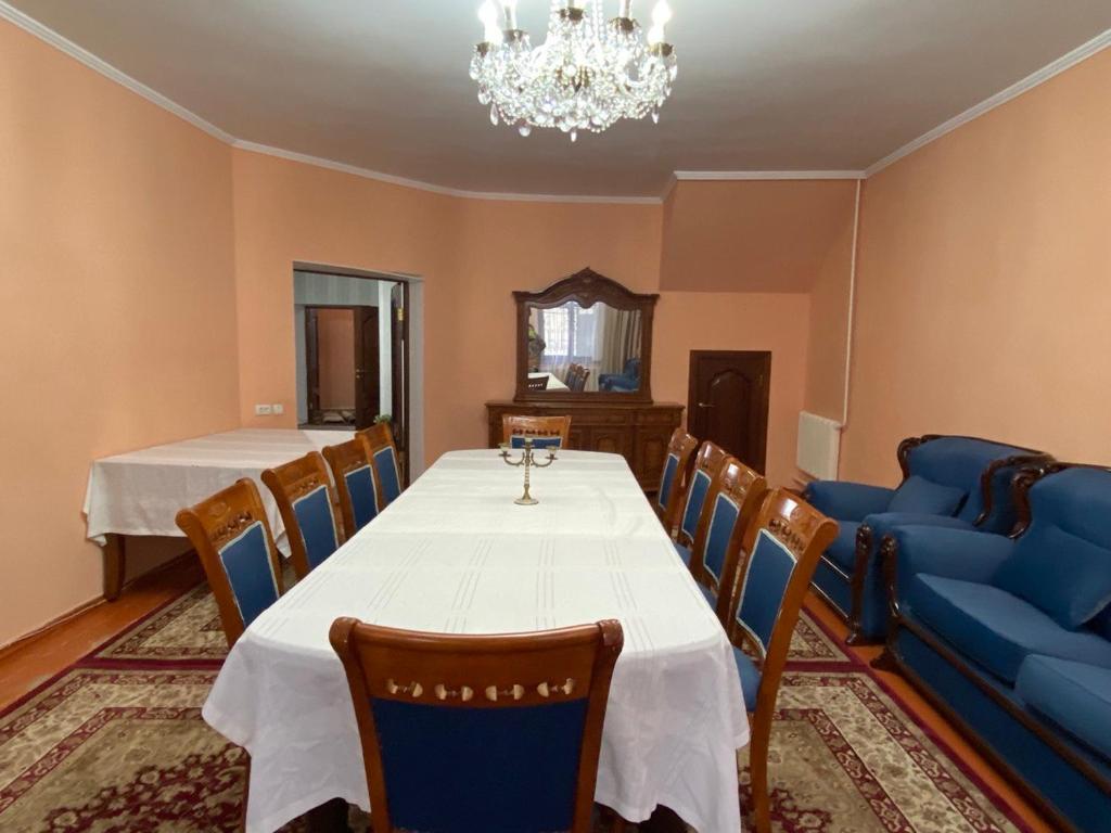 奇姆肯特Мини-гостиница АЙ的一间带桌子和蓝色沙发的用餐室