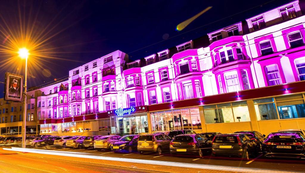 布莱克浦蒂凡尼酒店的一排汽车停在一座紫色灯的建筑前面
