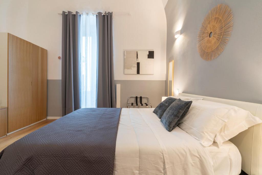 塔兰托SoClà Boutique Hotel的卧室配有一张带白色床单和枕头的大床。