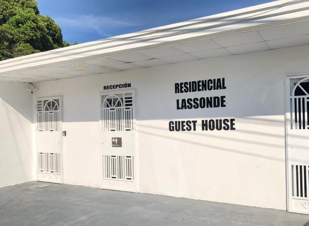 戴维Residencial Lassonde Guest House的白色的建筑,上面有宾馆标志