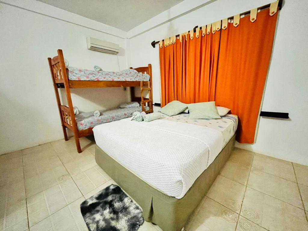 伊瓜苏港Hiraya Apart的一间卧室配有一张带橙色窗帘的床