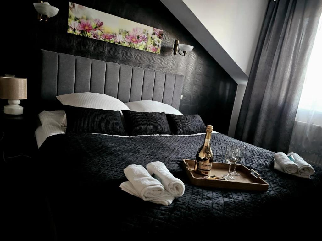 赫鲁别舒夫Hotel Kasieńka的一间卧室配有一张带毛巾和一瓶香槟的床。