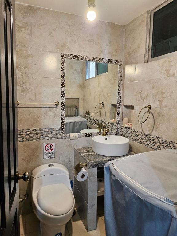 瓜亚基尔Blanca Apartments的一间带卫生间、水槽和镜子的浴室