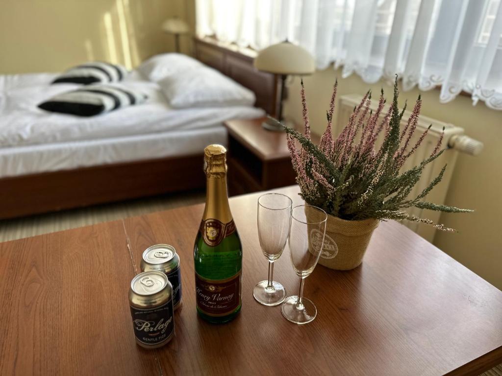 伊沃尼奇-兹德鲁伊GLORIETTA Apartments & SPA的卧室桌子上放了两瓶和眼镜