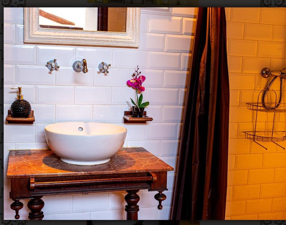 PenáguilaCasa Valor的木桌上设有白色碗水槽的浴室