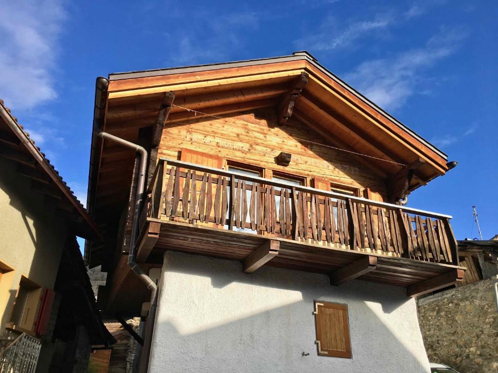 Chermignon-dʼen HautChalet typique du Valais,Maison bio et bien-être!的大楼一侧的木制阳台