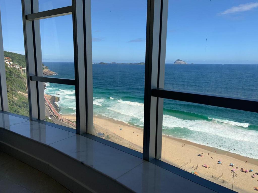 里约热内卢Hotel Nacional RJ - Vista Mar的透过窗户可欣赏到海滩景色的客房