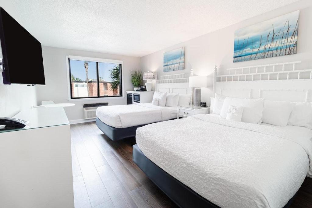 帕瓦雷斯岛Beach Vibes with Great Amenities on the 2nd Floor的一间白色卧室,配有两张床和一台平面电视