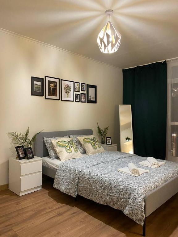 华沙HALBY rooms Rondo ONZ的一间卧室配有一张大床和一个吊灯。