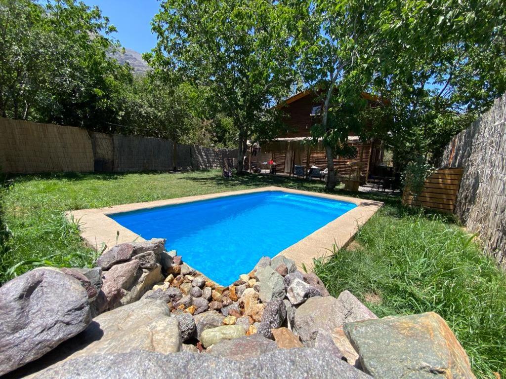 MelocotónCabaña en San Jose de Maipo的一座位于岩石庭院内的游泳池