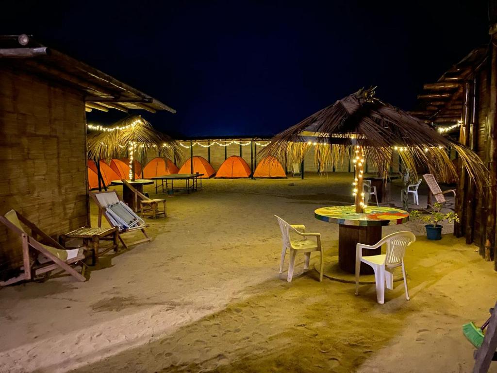 曼克拉Pepon Surf Camp的一组桌椅和帐篷