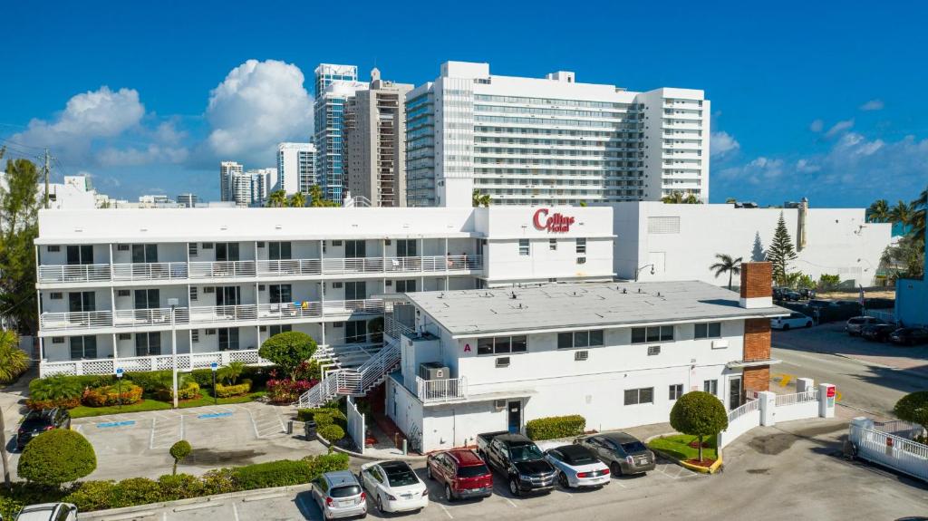 迈阿密海滩柯林斯酒店的一座白色的大建筑,汽车停在停车场