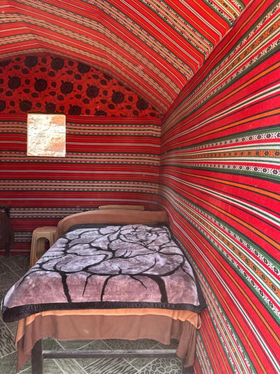 瓦迪拉姆Mohammed Wadi Rum Camp的一张位于墙上的床位,有条纹