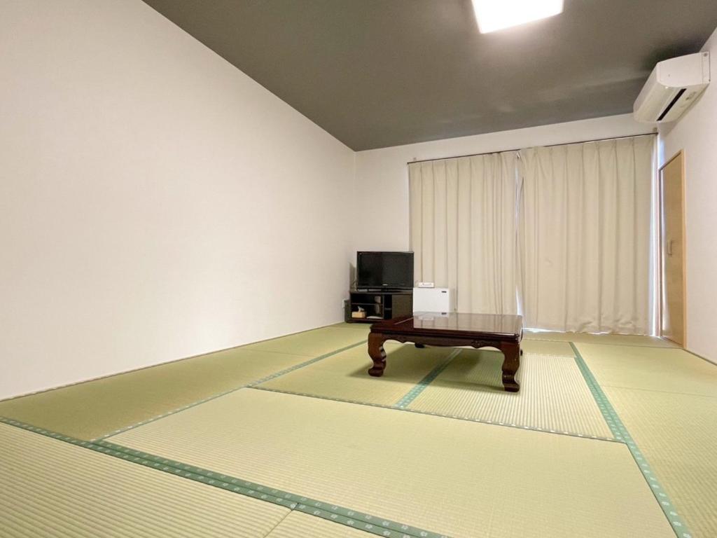 天草市Eimiya Ryokan - Vacation STAY 36348v的一间房间,里面设有桌子和电视
