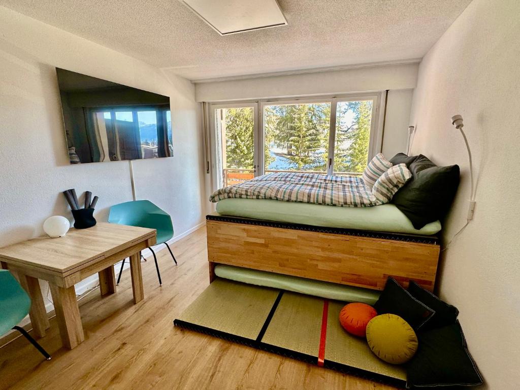 克莱恩 蒙塔纳Studio Serenity, 4 min walk to ski!的一间卧室配有一张带窗户和桌子的床