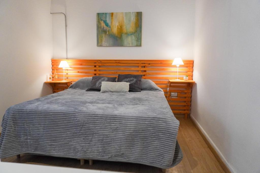 上格拉西亚Solar del Tajamar的一间卧室配有一张大床和两盏灯
