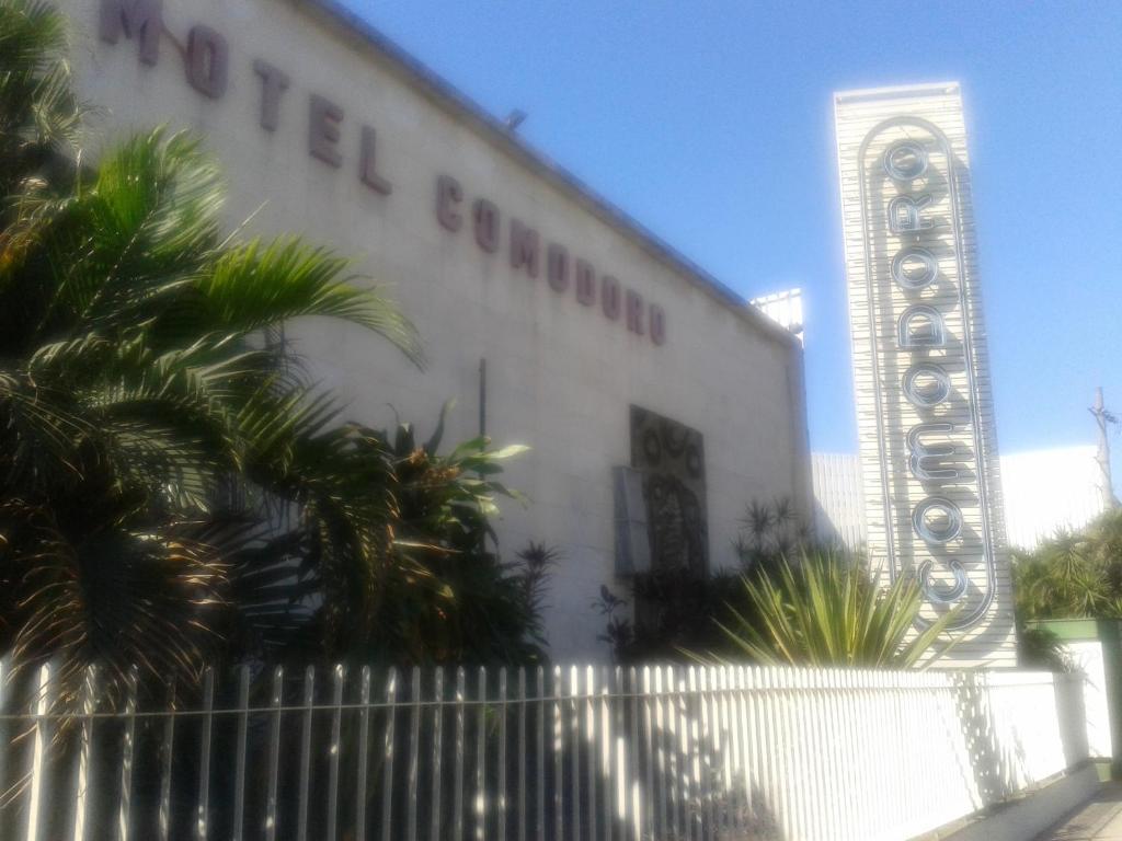 里约热内卢卡门多乐汽车旅馆（仅限成人）的白色的建筑,旁边标有标志