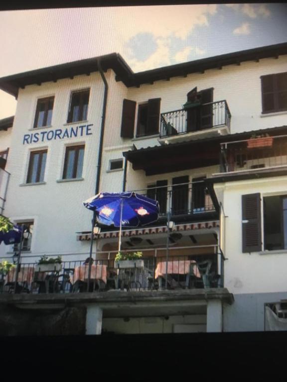 NovaggioRistorante Bar Pensione Novaggio的前面有一把伞和椅子的建筑