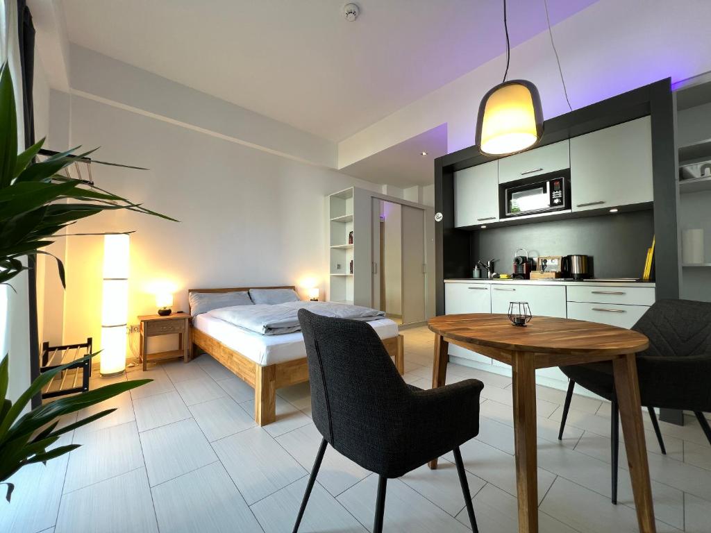 卡尔斯鲁厄The East Apartment by Rabe - Netflix & Coffee & Parkplatz的卧室配有一张床和一张桌子及椅子