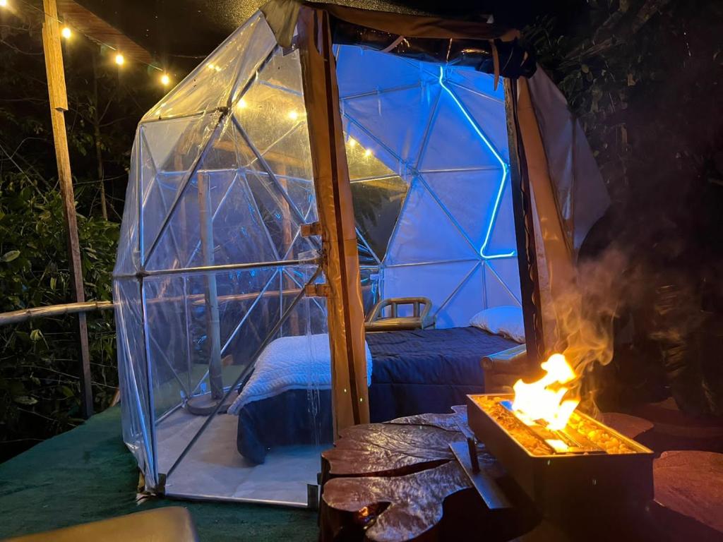 圣弗朗西斯科Mirador de la Montaña Glamping的圆顶帐篷内的一张床位,配有壁炉