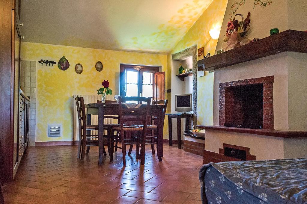 拉亚蒂科La Casanuova的一间带桌椅和壁炉的用餐室
