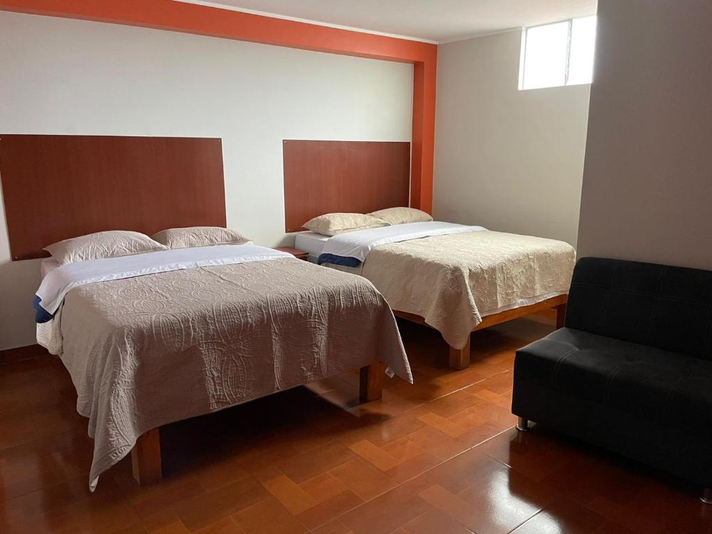 万卡约CASA HOSPEDAJE LAS MONTAÑAS的一间卧室配有两张床和椅子