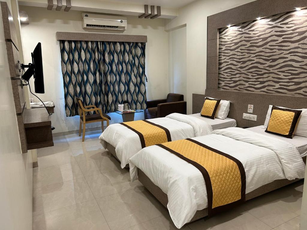 瓦皮Hotel Orange的酒店客房设有两张床和电视。