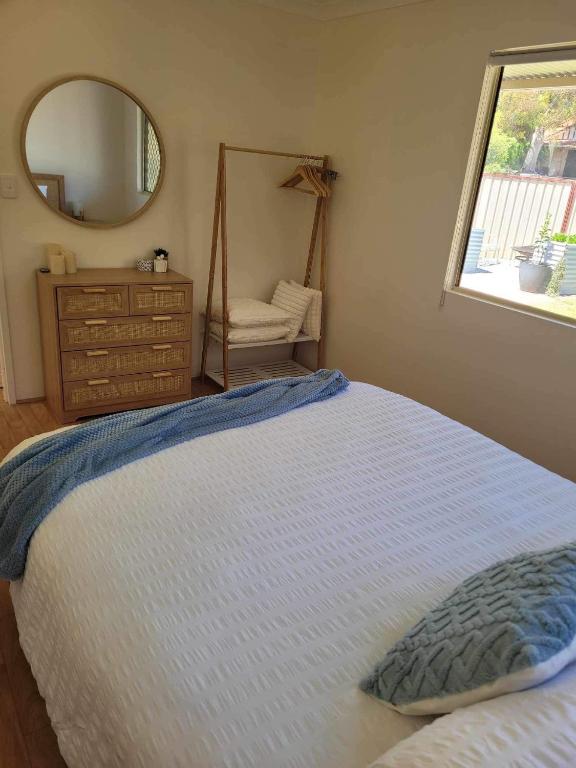 WarnbroG&R Beach Cottage的一间卧室配有一张带镜子和梳妆台的床