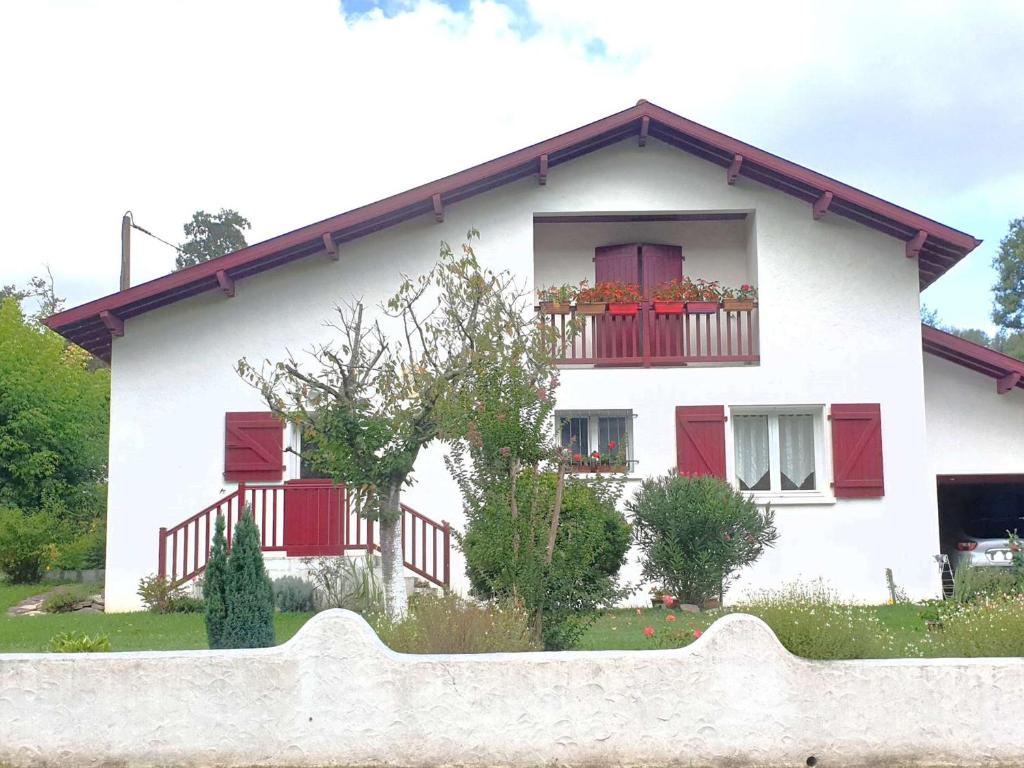BriscousVilla Briscous, 5 pièces, 8 personnes - FR-1-3-603的白色的房子,设有红色的窗户和栅栏
