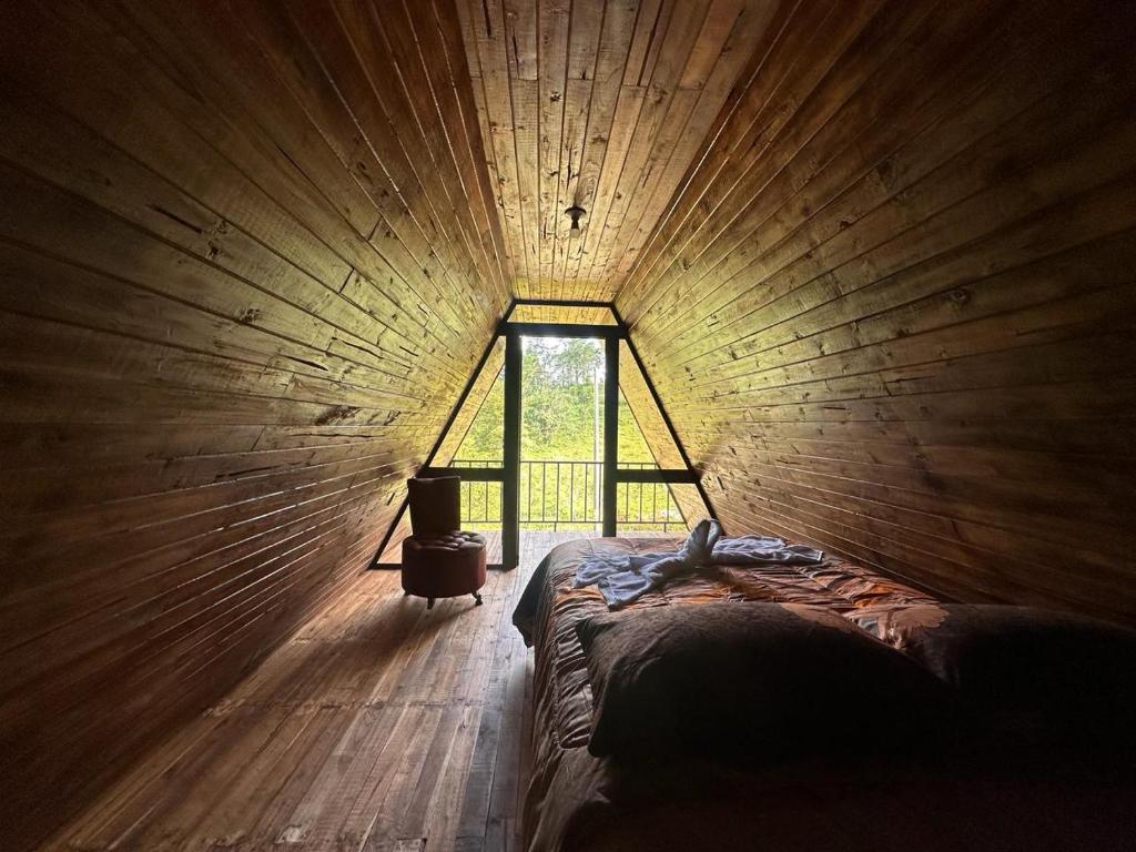 San RafaelBungalow Tenorio Mountain Lodge的一间设有一张床铺的木房间,设有窗户