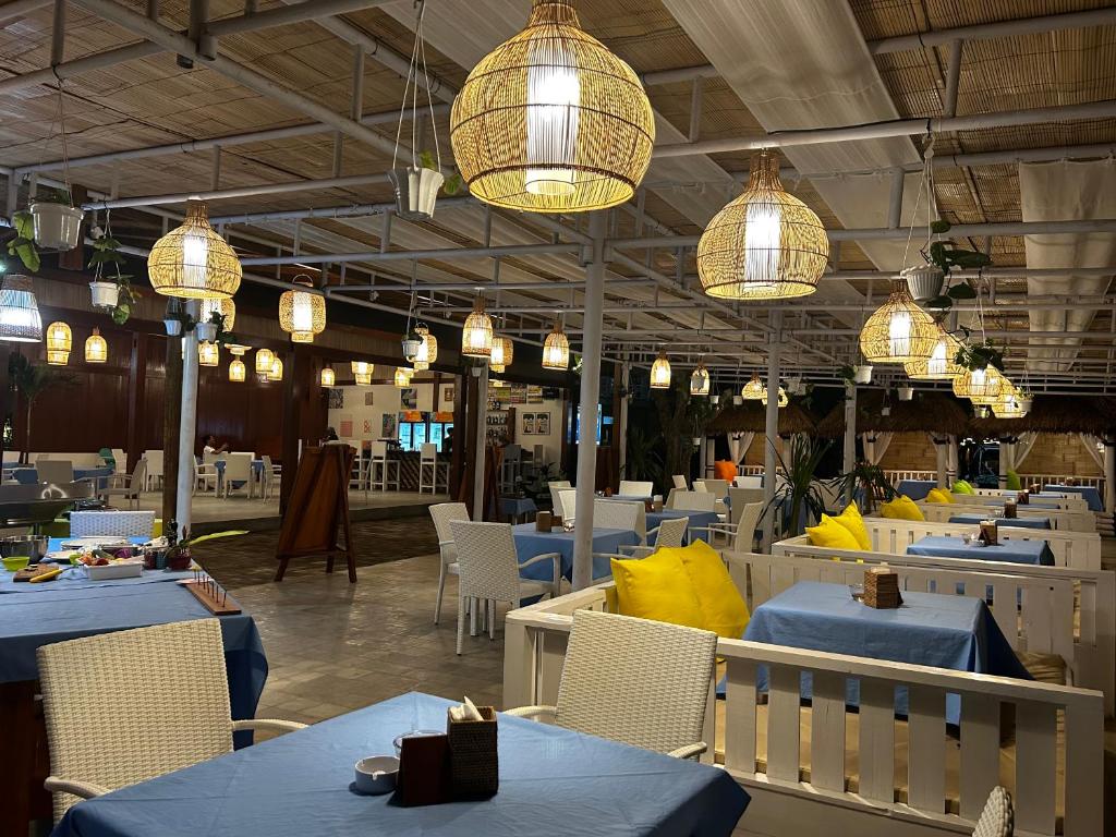 吉利阿尔吉利艾尔优泽普度假酒店的餐厅设有蓝色的桌椅和灯光