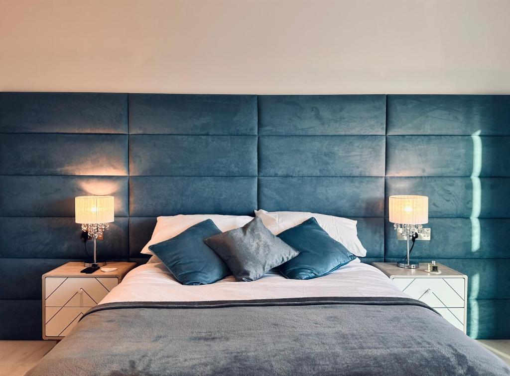 纽基34 Cliff Edge 2nd floor Newquay luxury sea-view residence的一间卧室配有一张带蓝色床头板的大床