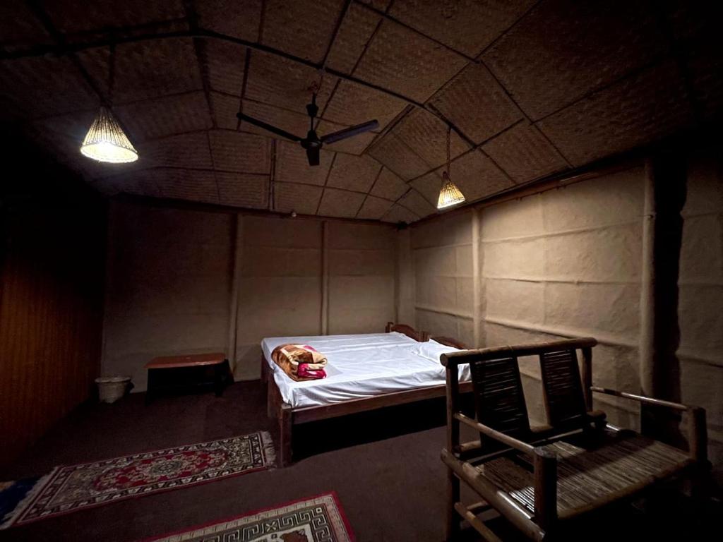 卡齐兰加Gorh Retreat的一间设有床和椅子的房间