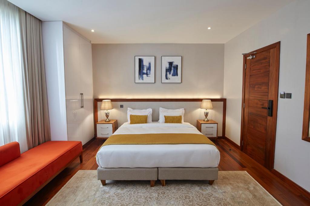 内罗毕Deerpark Luxury Stays的一间卧室配有一张大床和一张红色的沙发