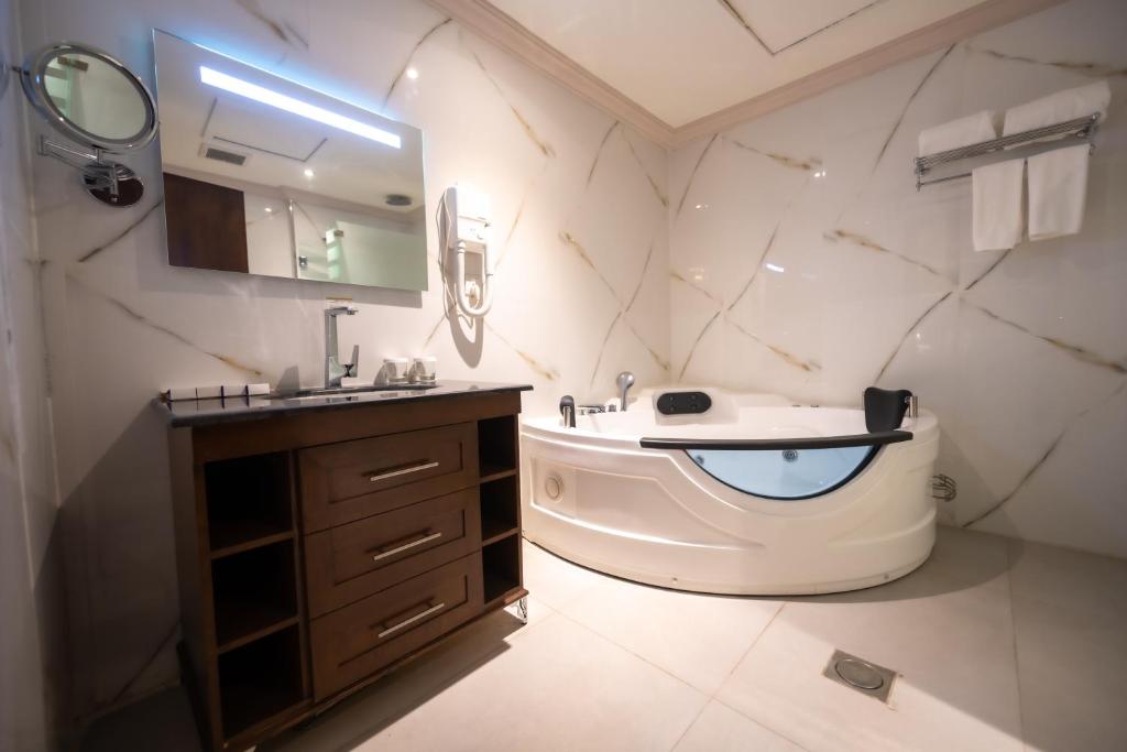 吉达WA Hotel的一间带水槽、浴缸和卫生间的浴室