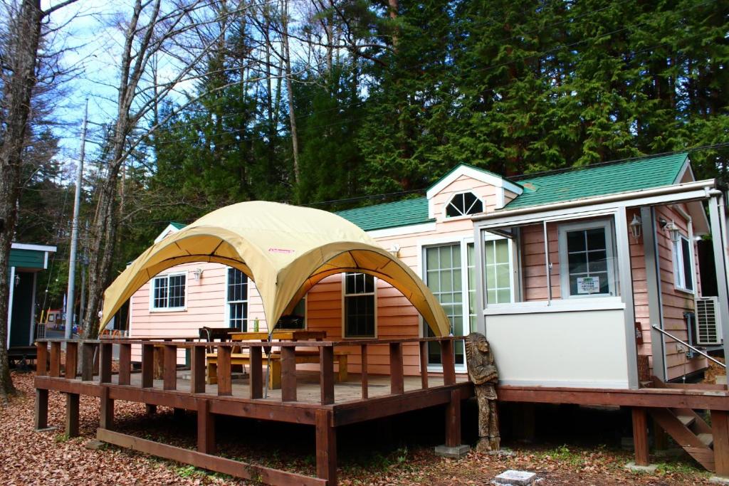 富士河口湖Work Shop Camp Resort Forest and Lake Paradise - Vacation STAY 85268v的一座带甲板和帐篷的小房子